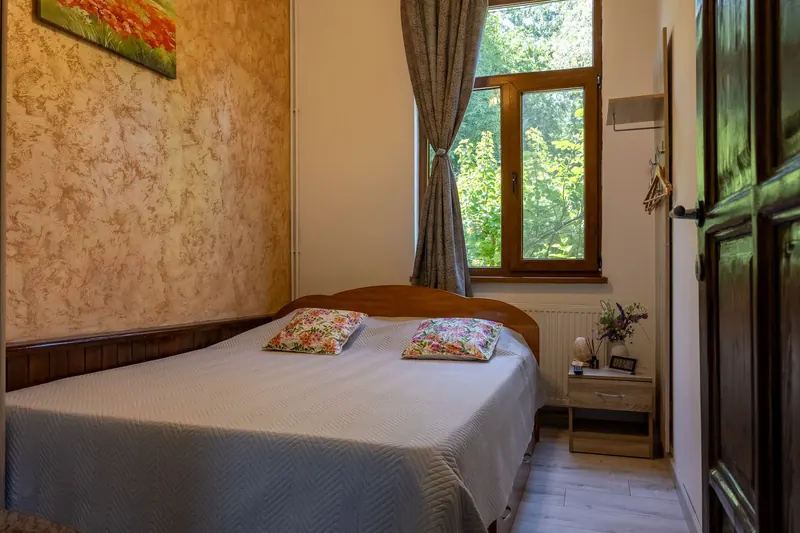 Dormitor matrimonial la parter, cu perete roz și tablou